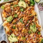 Loaded BBQ chicken nachos with guacamole and fresh cilantro