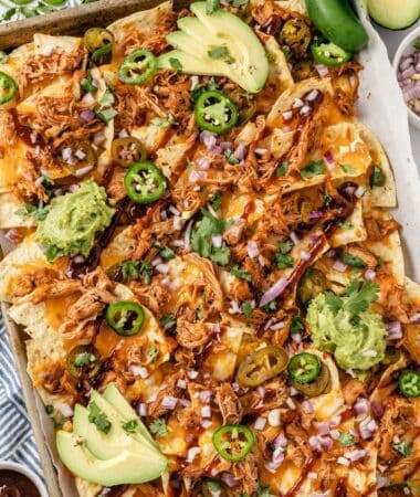 Loaded BBQ chicken nachos with guacamole and fresh cilantro