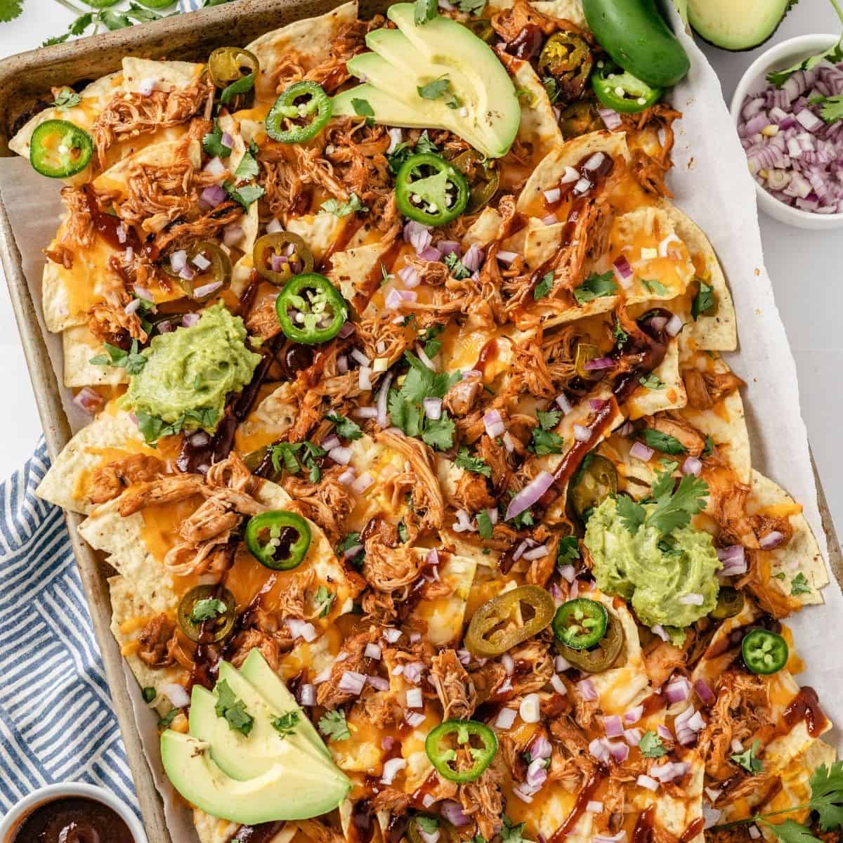 Loaded BBQ chicken nachos with guacamole and fresh cilantro