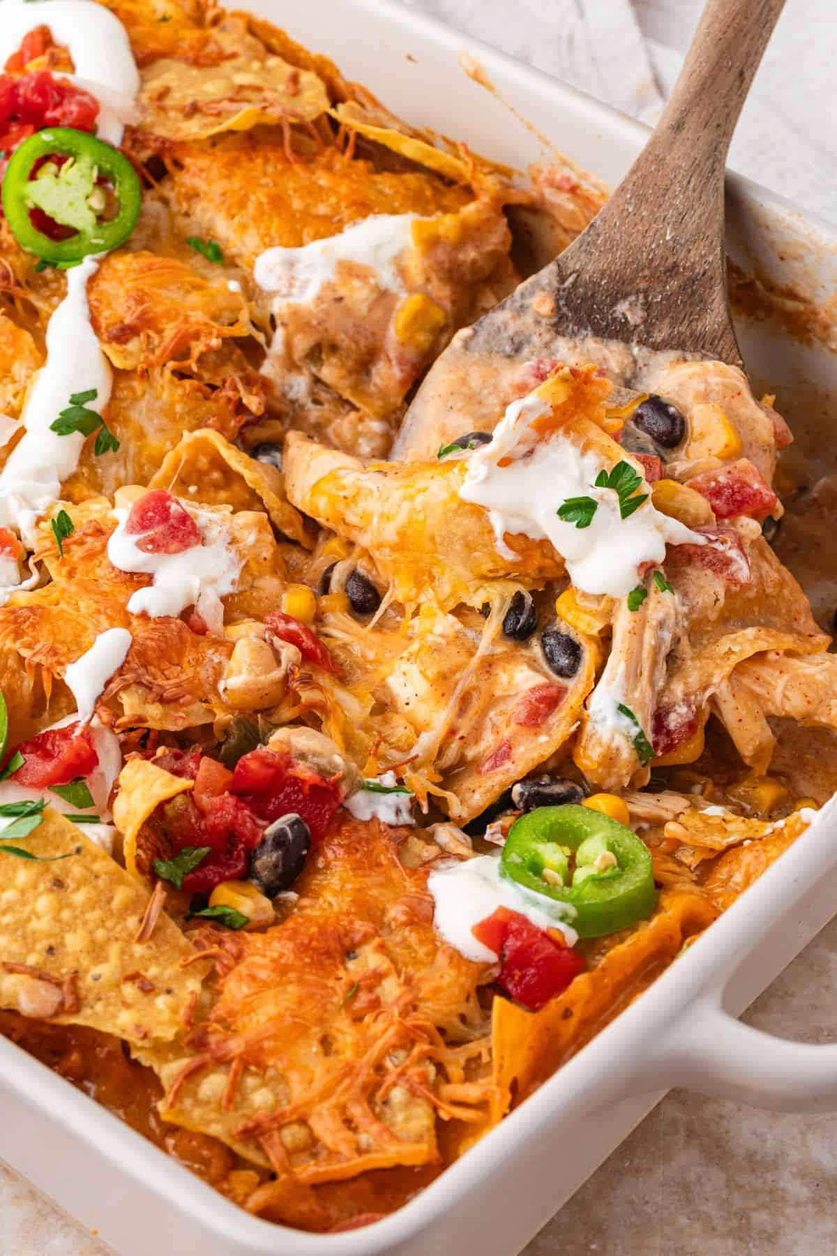 Mexican chicken casserole baked with cheese, beans, corn, and tortilla chips