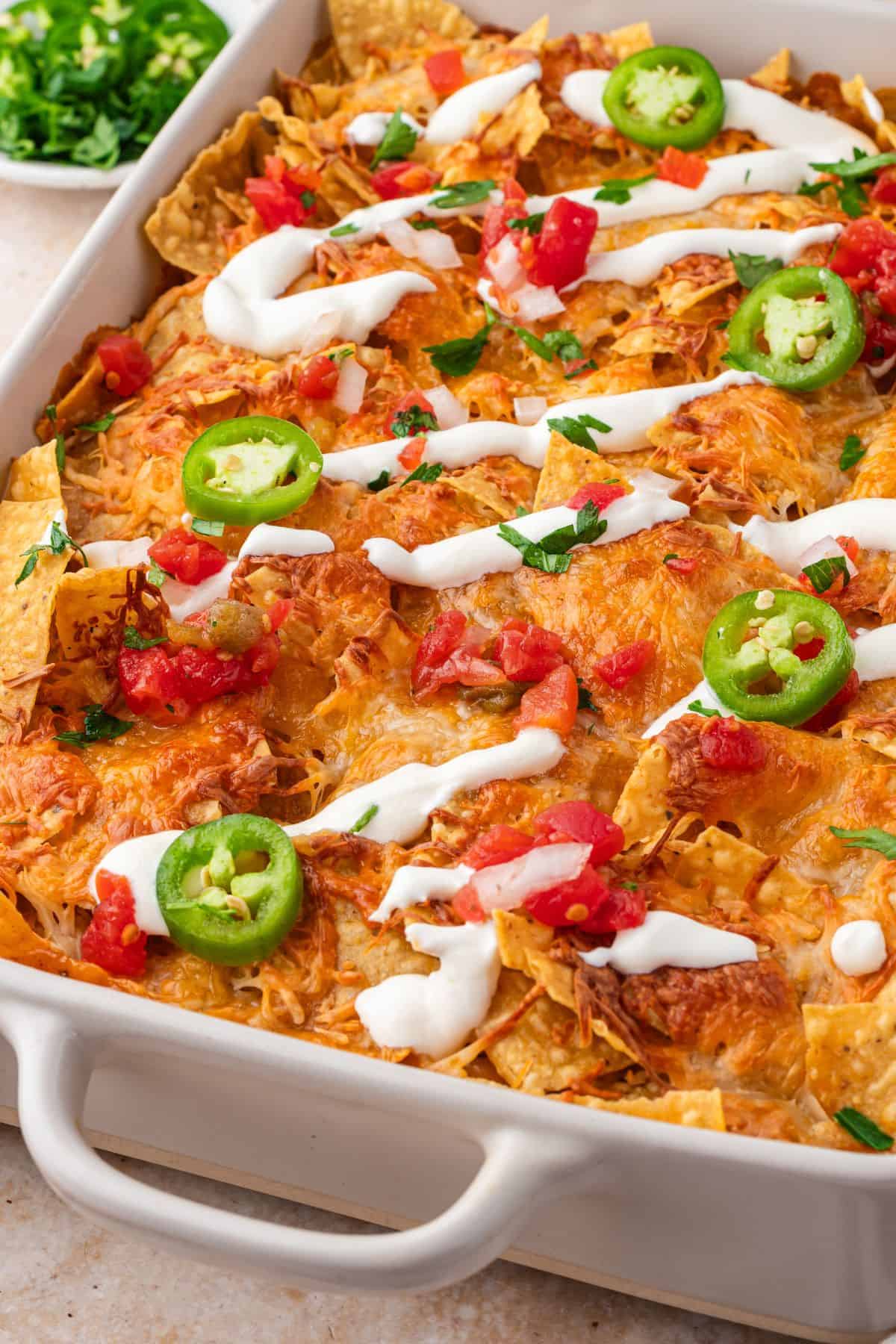 Mexican chicken casserole with tortillas, melted cheese, and fresh toppings