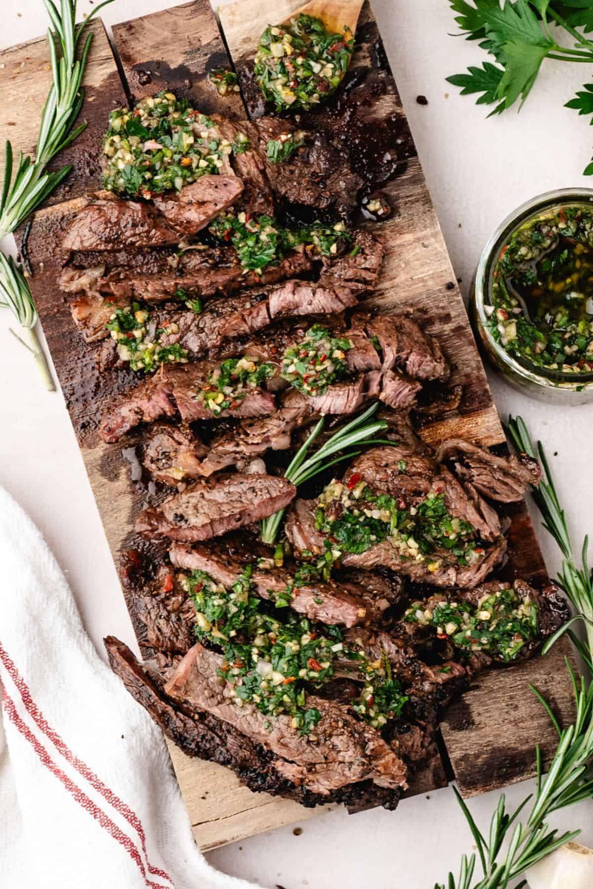 Fresh chimichurri sauce made with parsley, garlic, and olive oil poured over steak