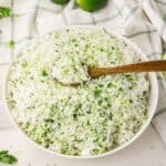 Rice with cilantro and lime in a bowl with bright green herbs