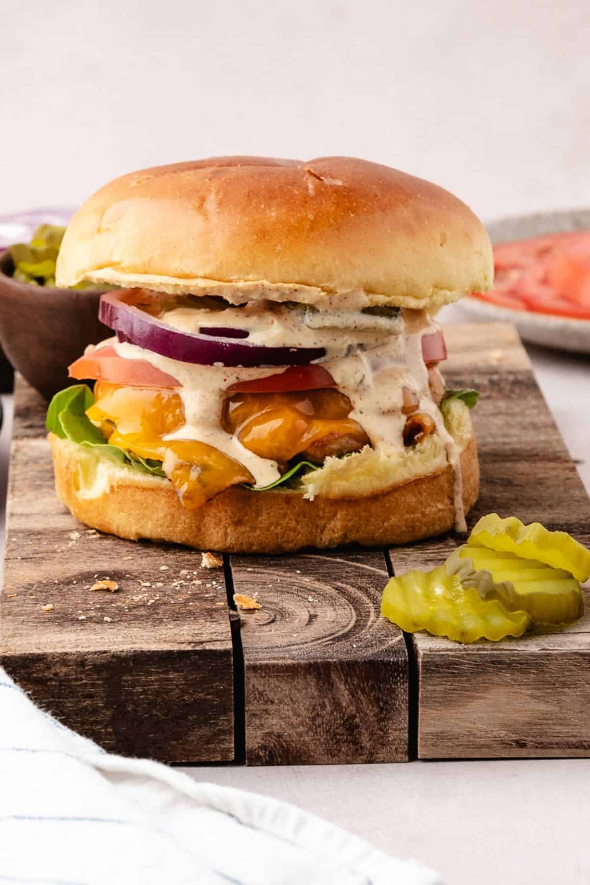 Ground chicken burger plated with toasted buns and fresh vegetables