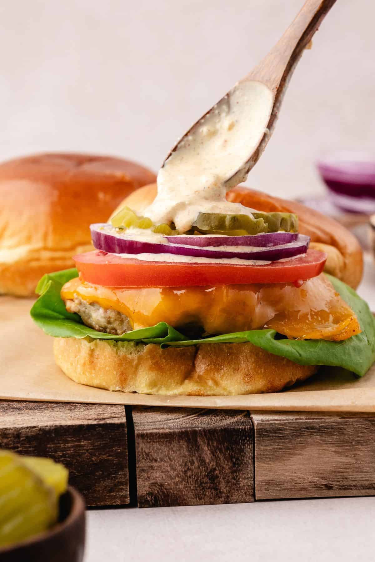 Ground chicken burger stacked high with onion, tomato, and lettuce