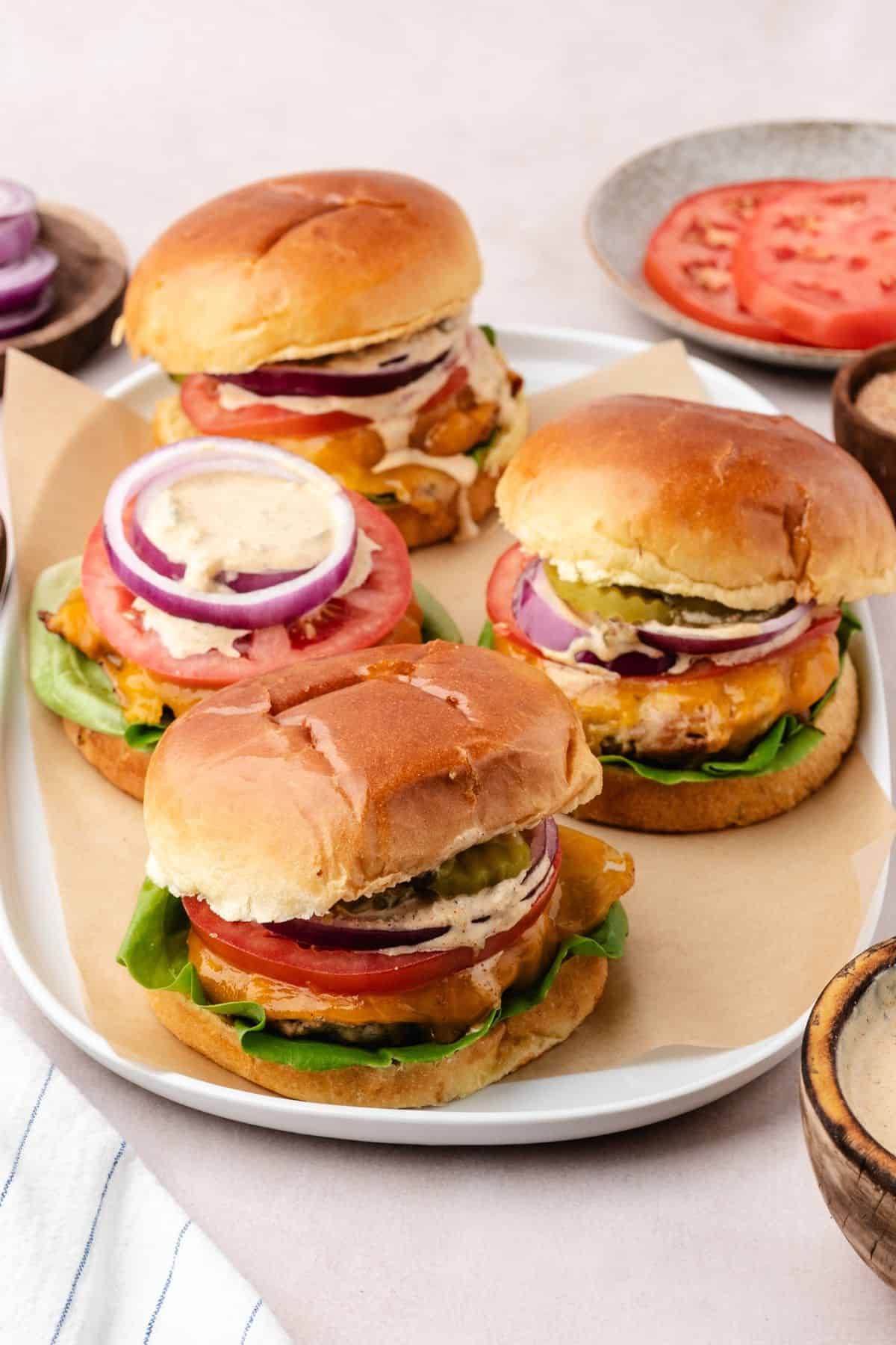 Ground chicken burgers served with classic toppings on brioche buns
