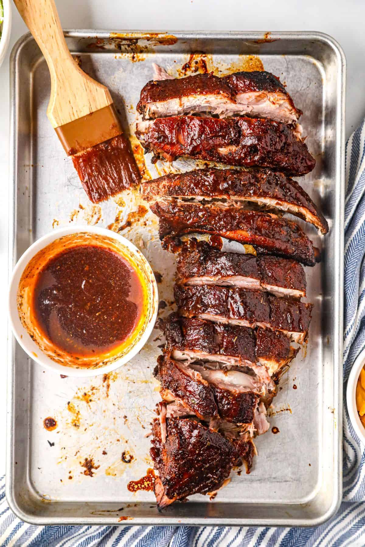 Juicy slow cooker ribs coated in barbecue glaze with extra sauce
