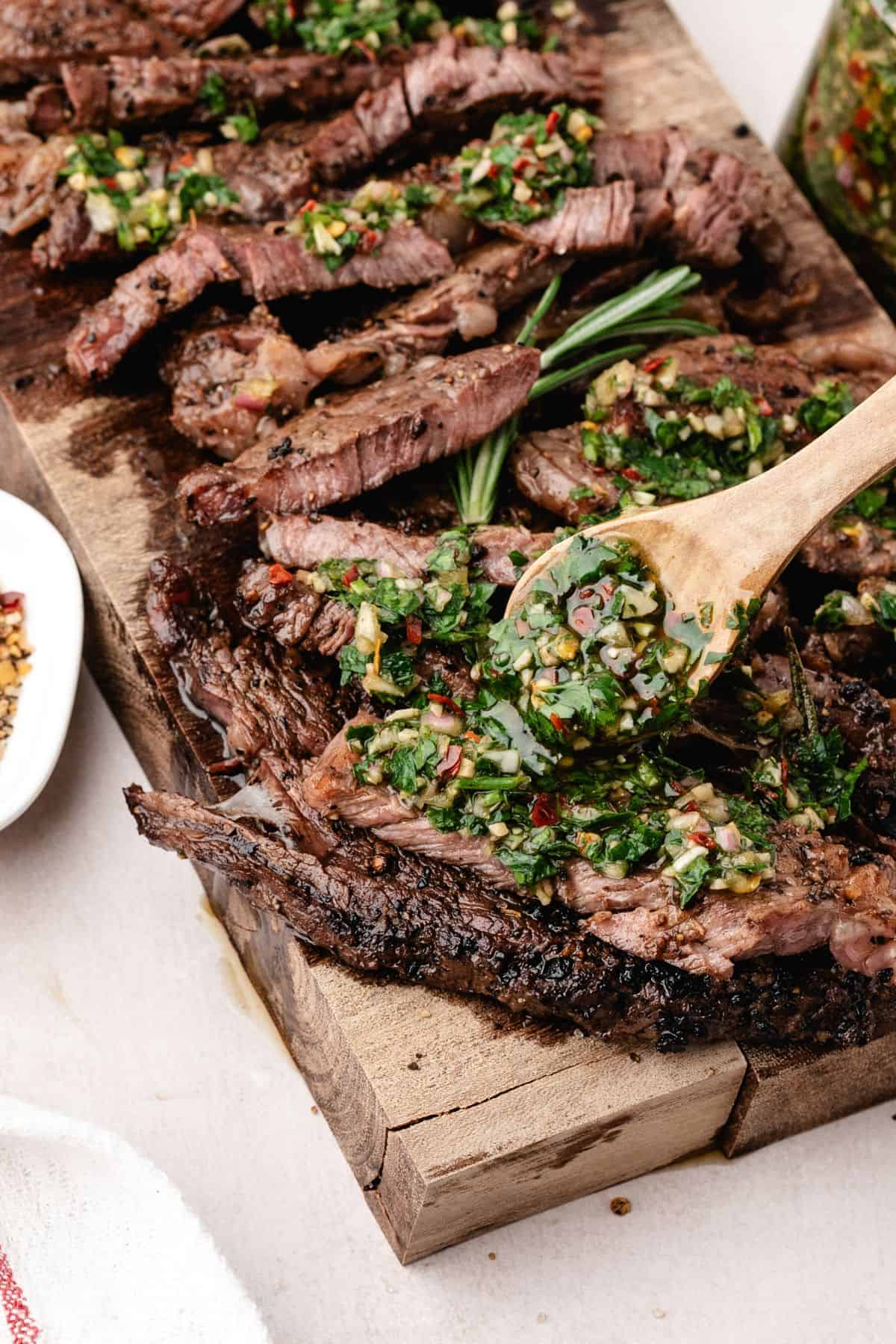 Pan seared steak served with chimichurri sauce and fresh herbs