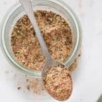 Homemade pork chops seasoning with paprika, onion powder, and herbs