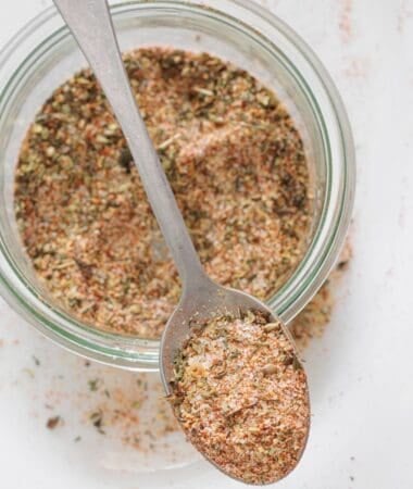 Homemade pork chops seasoning with paprika, onion powder, and herbs