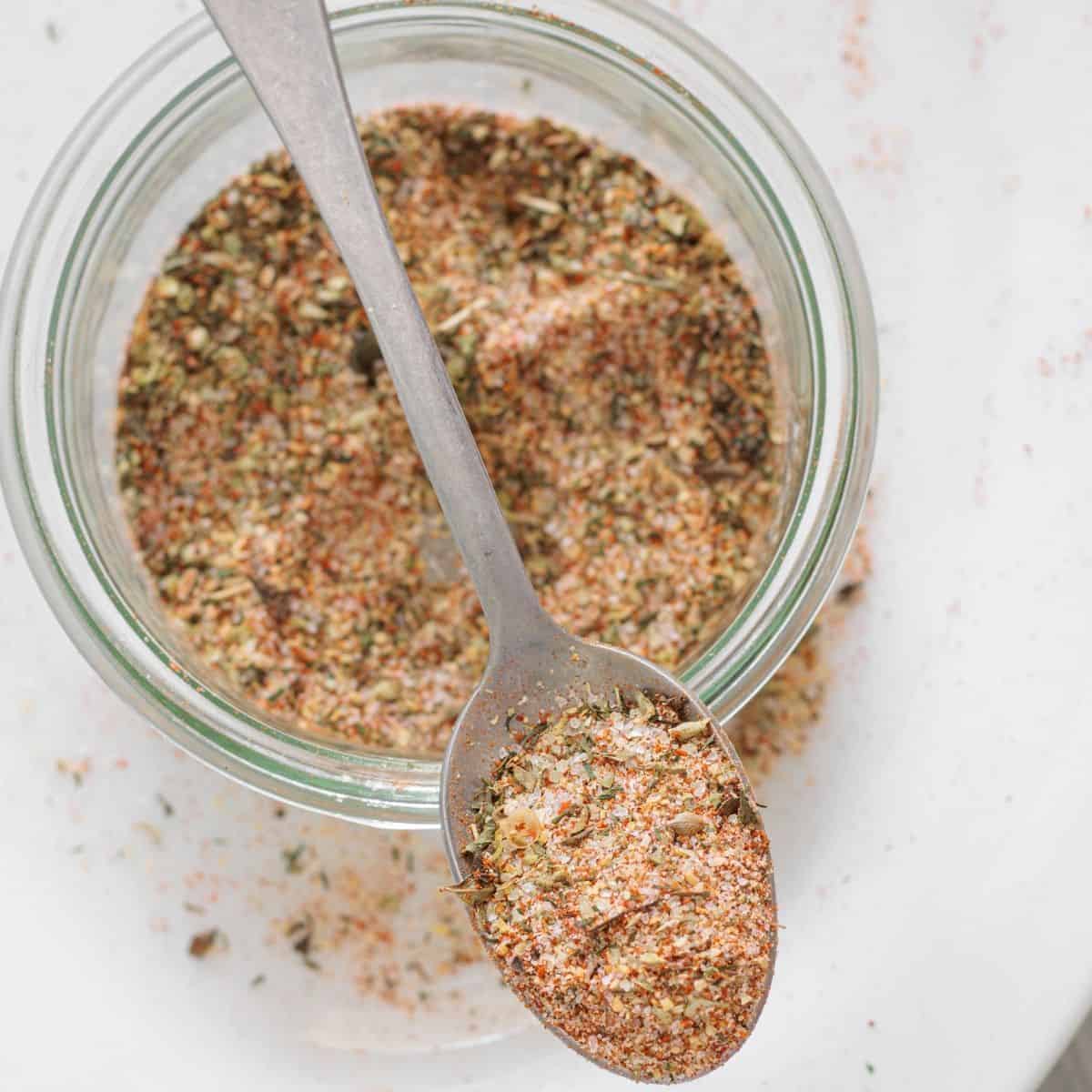 Homemade pork chops seasoning with paprika, onion powder, and herbs