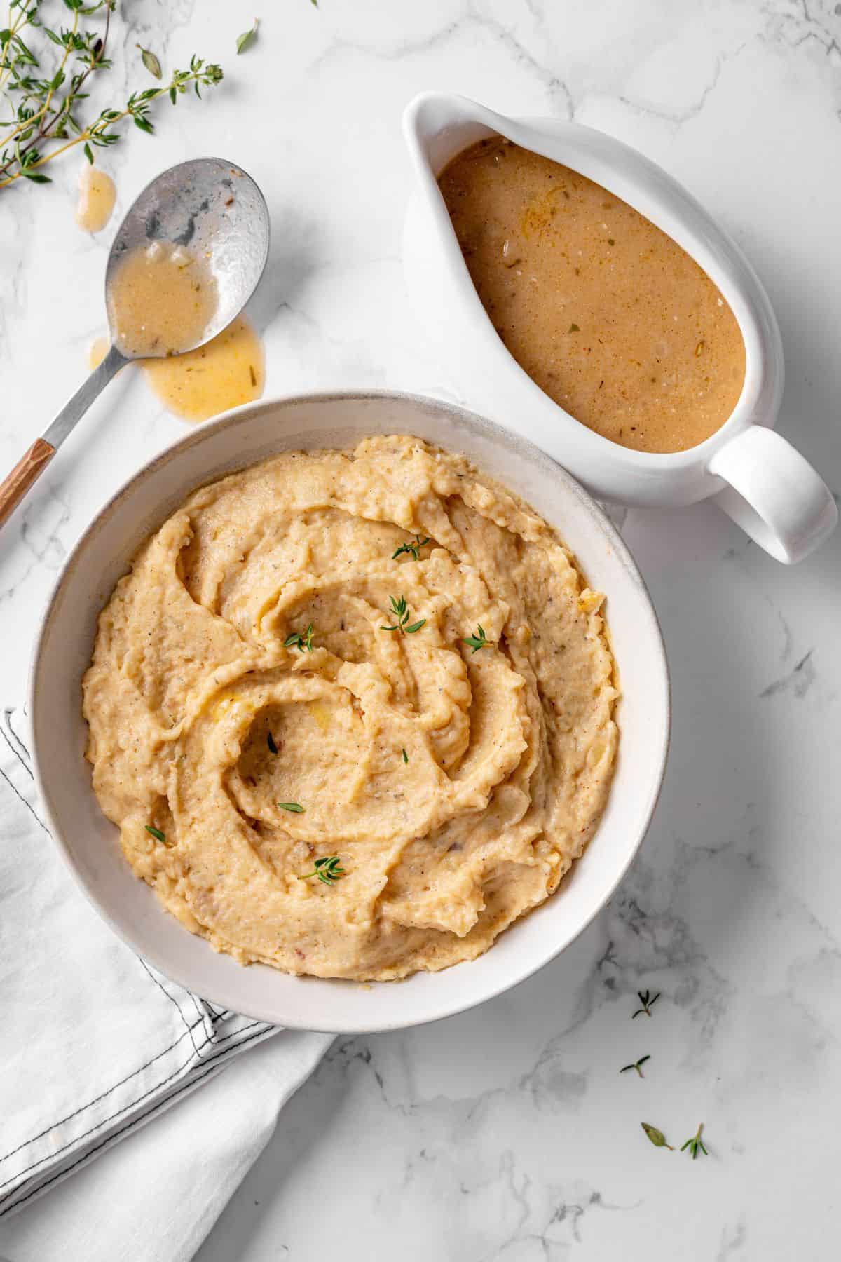 Make ahead turkey gravy with rich golden brown color poured over creamy mashed potatoes