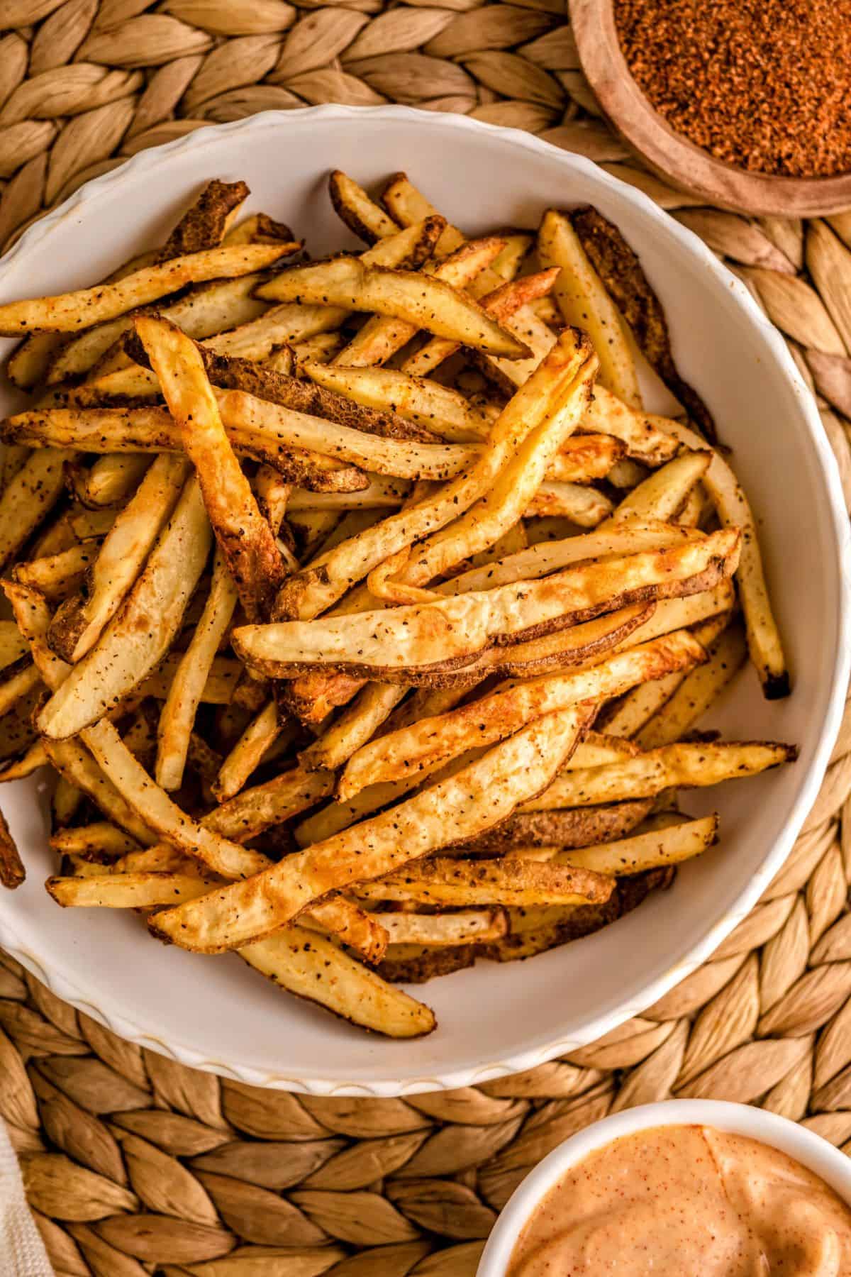 Homemade French fries in an air fryer with crispy Cajun-seasoned coating