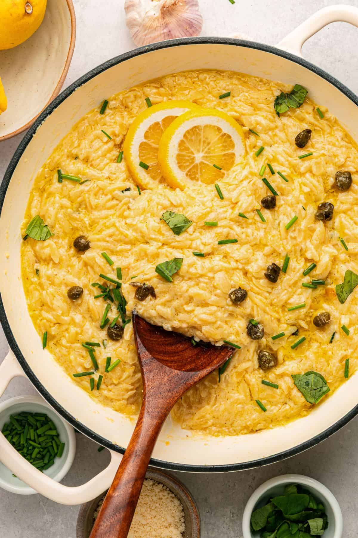 Lemon orzo skillet topped with fresh herbs and grated Parmesan