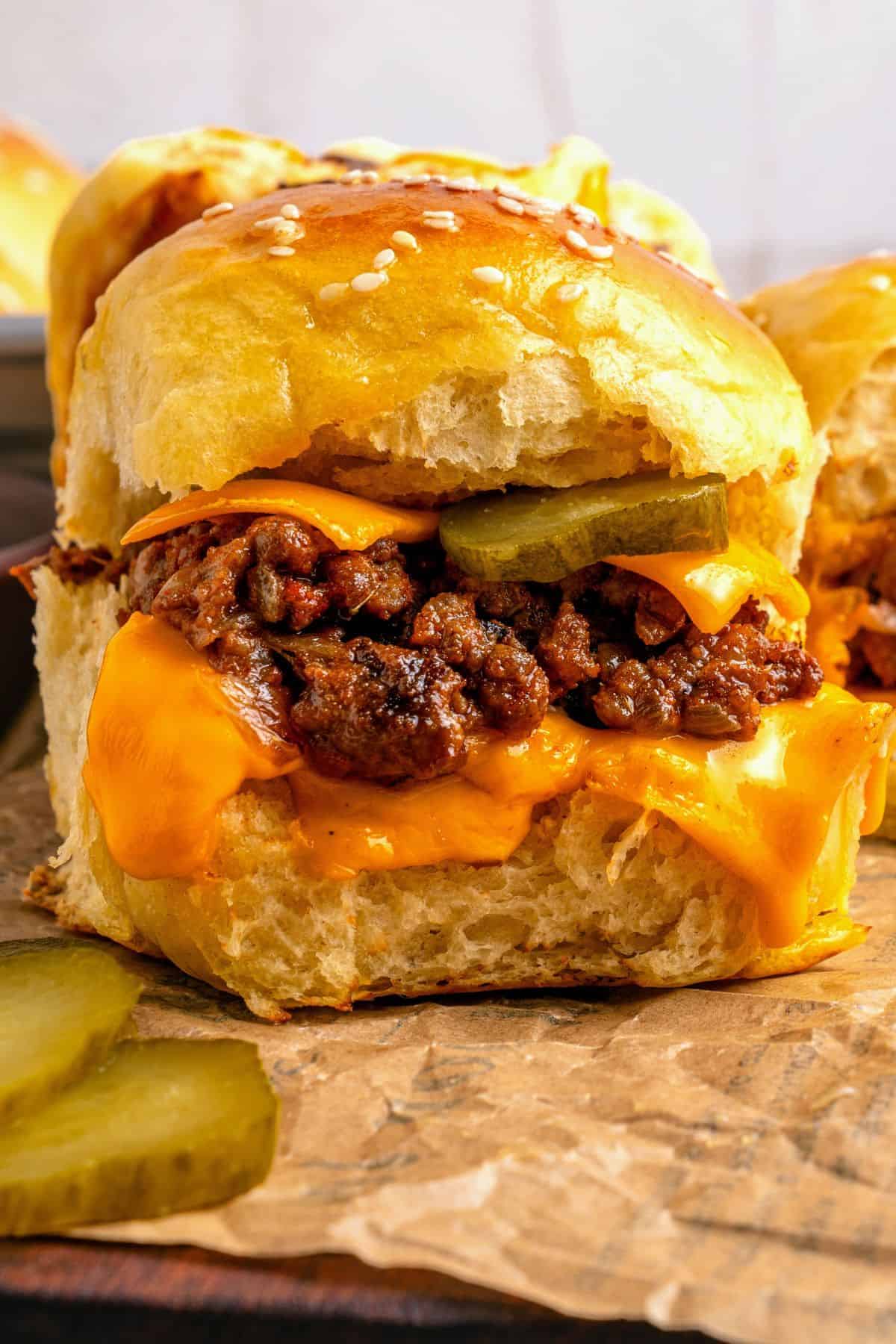 Cheeseburger sliders Hawaiian rolls with layers of beef, cheese, onions, and pickles