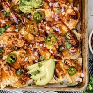 Shredded BBQ chicken nachos with melted cheese and BBQ sauce drizzle ready for game day