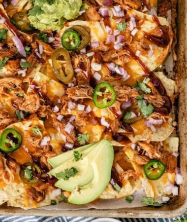 Shredded BBQ chicken nachos with melted cheese and BBQ sauce drizzle ready for game day