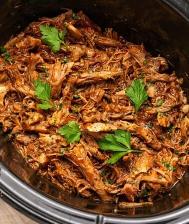 Pulled pork slow cooker recipe with juicy shredded pork and tangy BBQ sauce