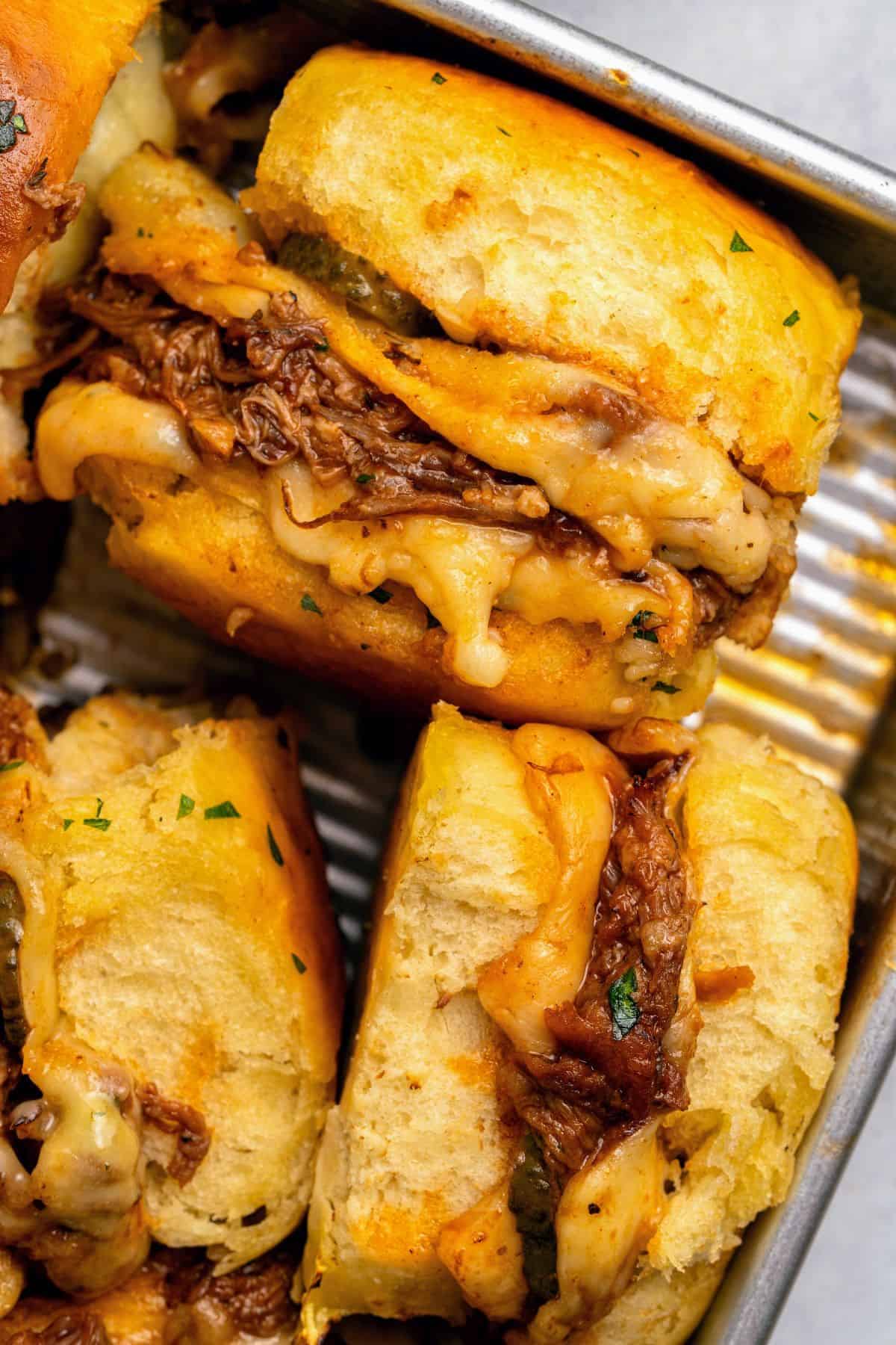 Hawaiian roll pulled pork sliders served warm with tangy dill pickles