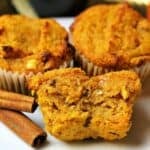 three keto pumpkin spice muffins with pecans on a white plate