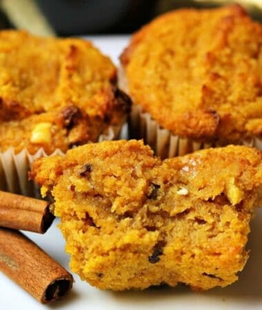 three keto pumpkin spice muffins with pecans on a white plate