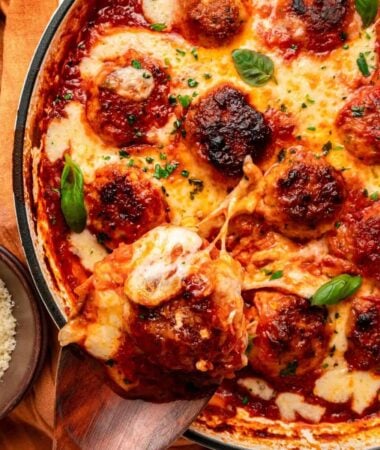 Skillet chicken parm meatballs covered with bubbling mozzarella and Parmesan