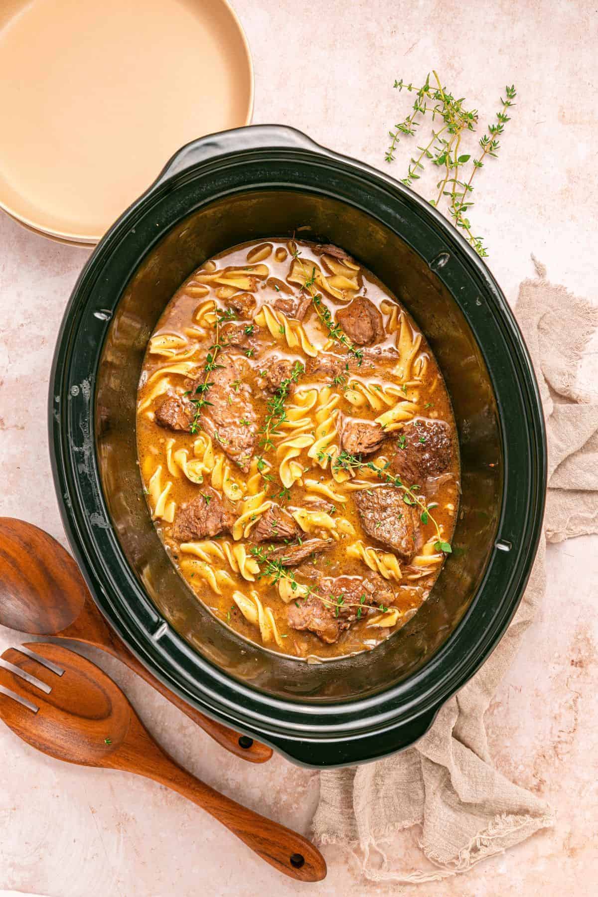 Beef and noodles in a slow cooker cooked until the beef is tender