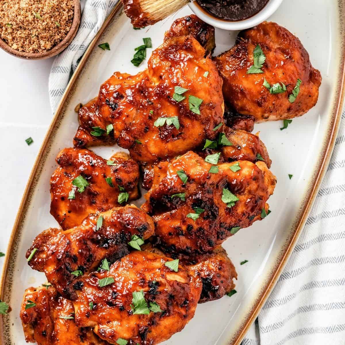 Boneless skinless BBQ chicken thighs brushed with BBQ sauce and baked