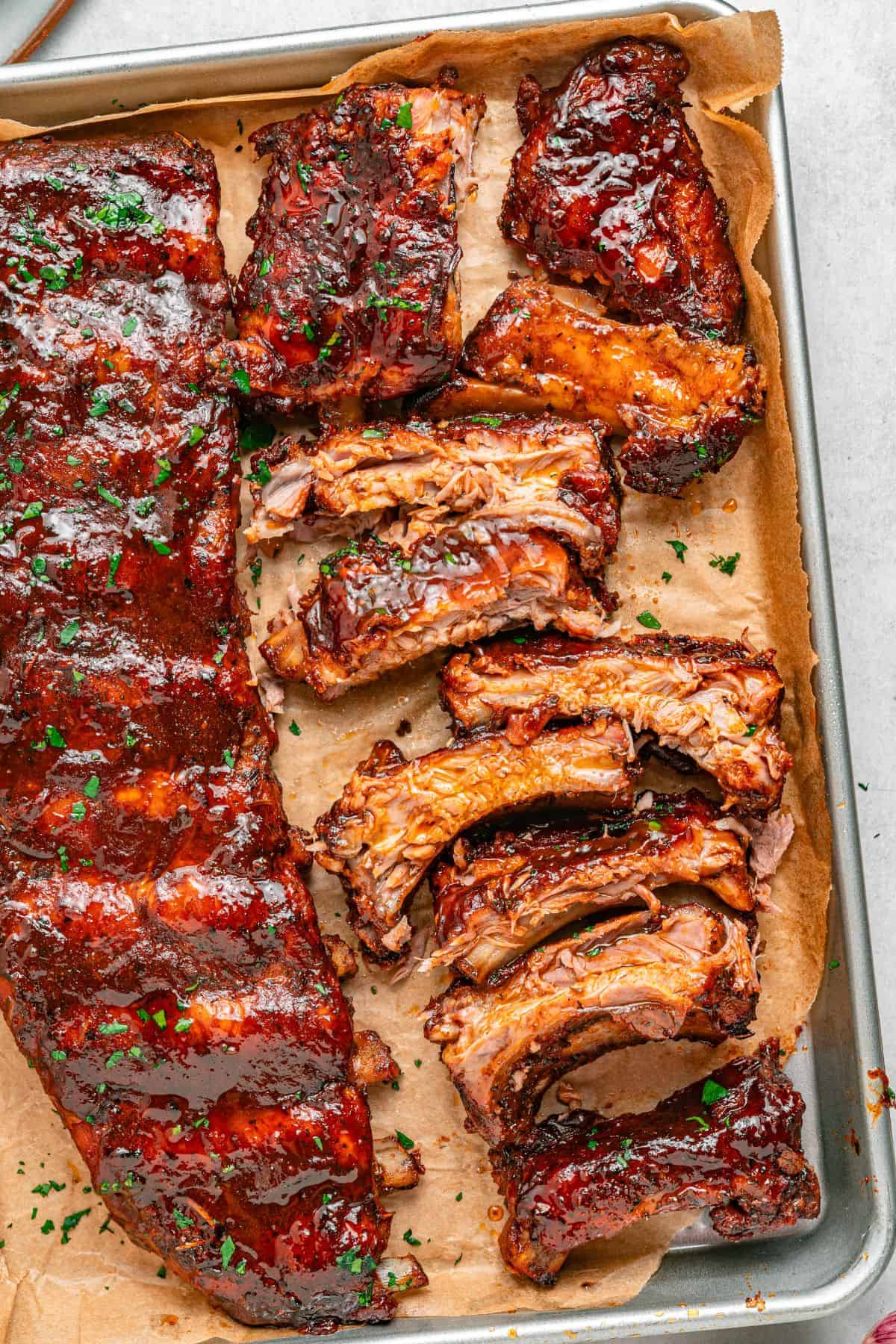 Ribs in the oven seasoned with dry rub and finished with BBQ sauce