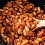 Crock pot baked beans with bacon simmered until thick and flavorful