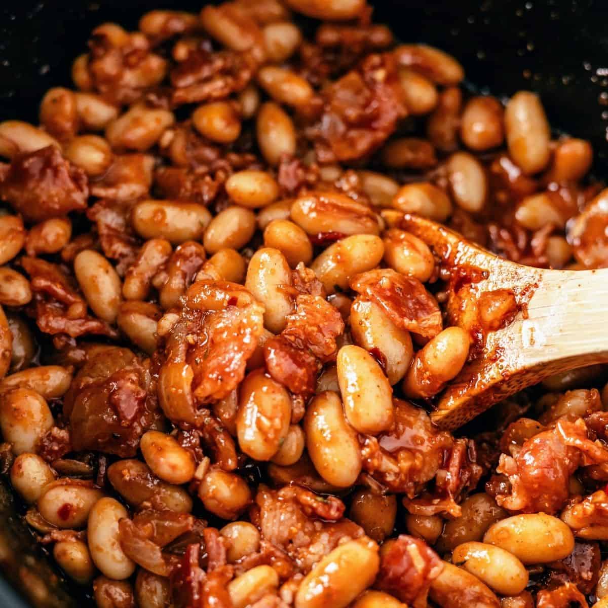 Crock pot baked beans with bacon simmered until thick and flavorful