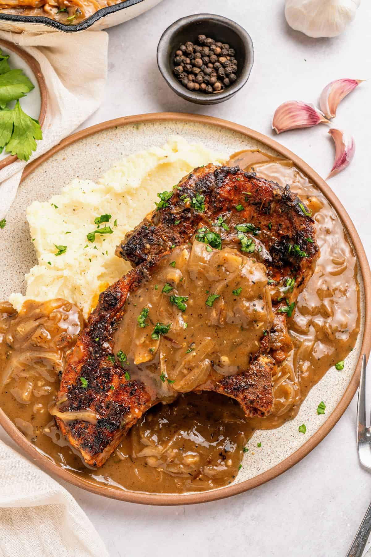 Smothered pork chops with onion gravy served hot with savory pan sauce