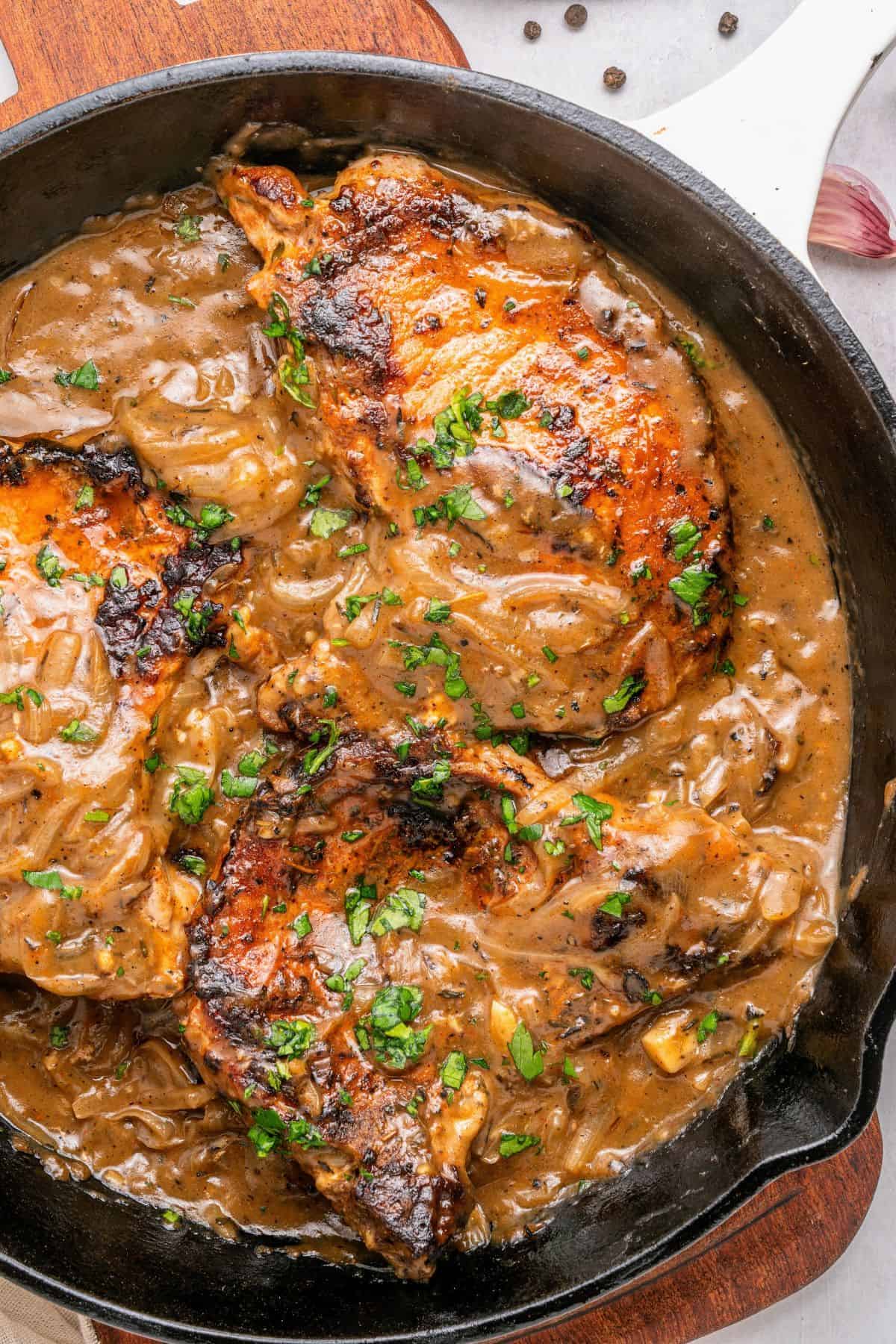 Southern smothered pork chops simmered in rich homemade onion gravy