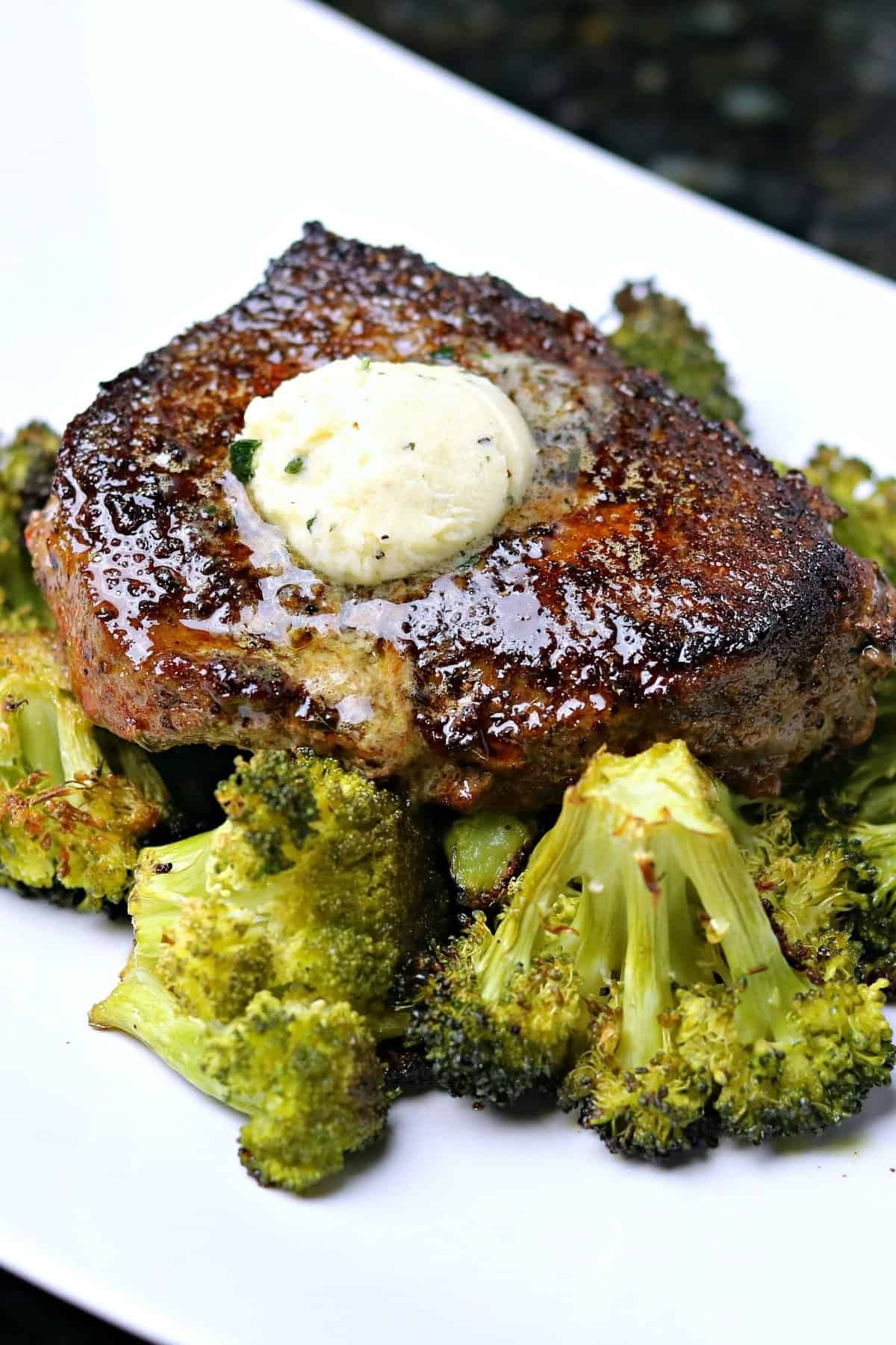 steak seasoned with ranch seasoning on a plate with broccoli topped with compound butter