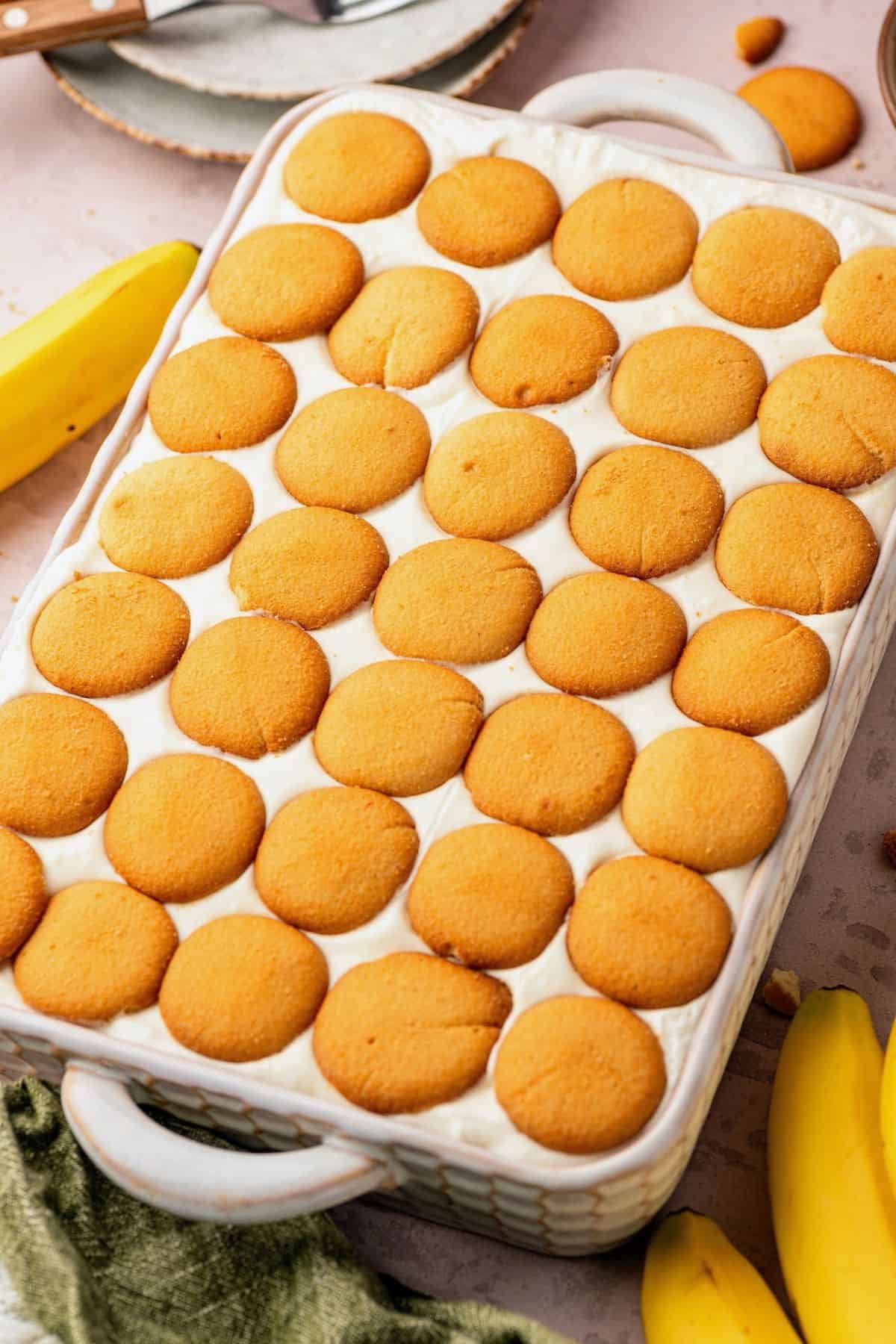 Homemade banana pudding with creamy whipped topping and rows of vanilla wafer cookies.