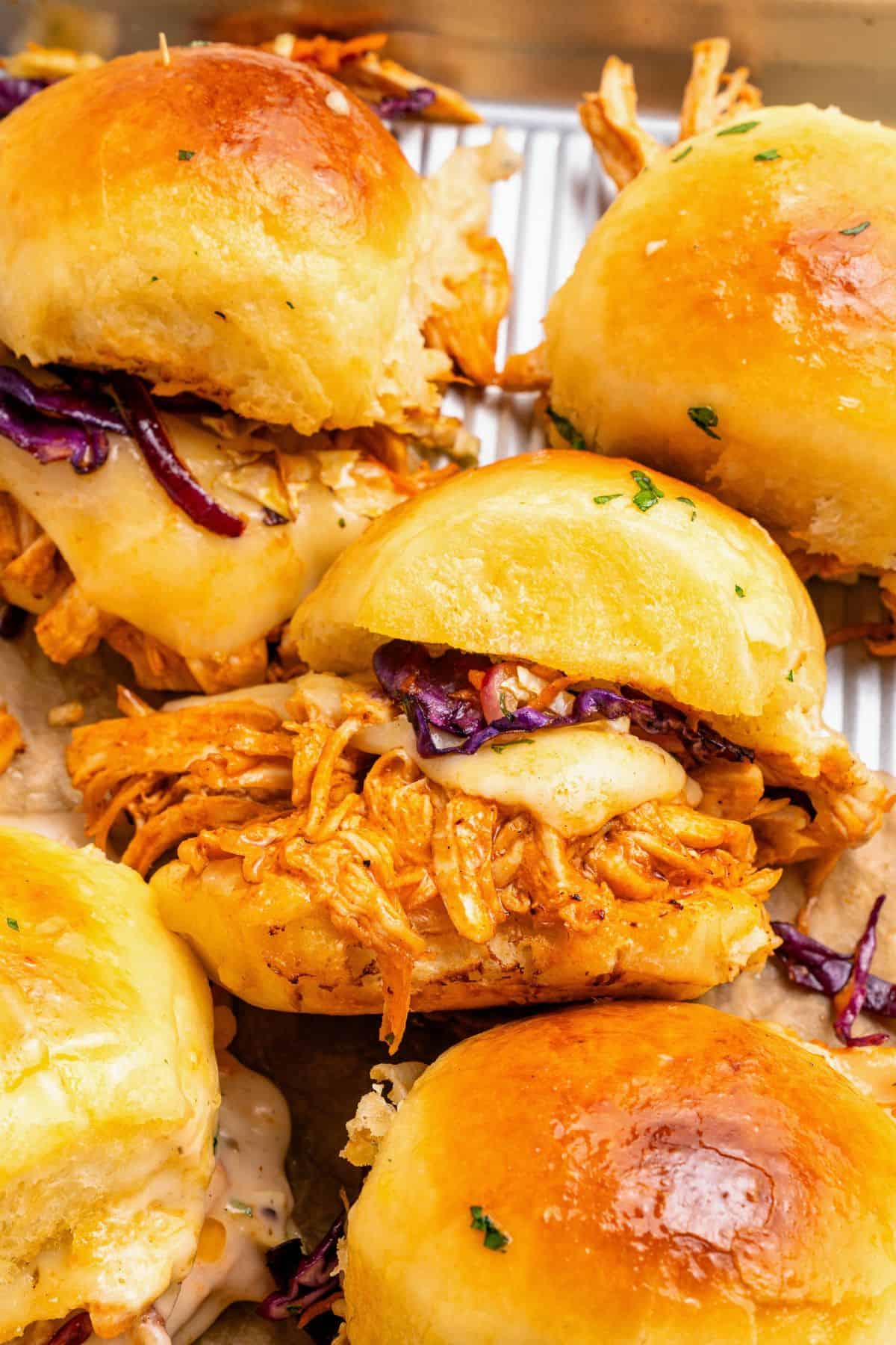 Buffalo chicken sliders with Hawaiian rolls filled with cheesy Buffalo chicken