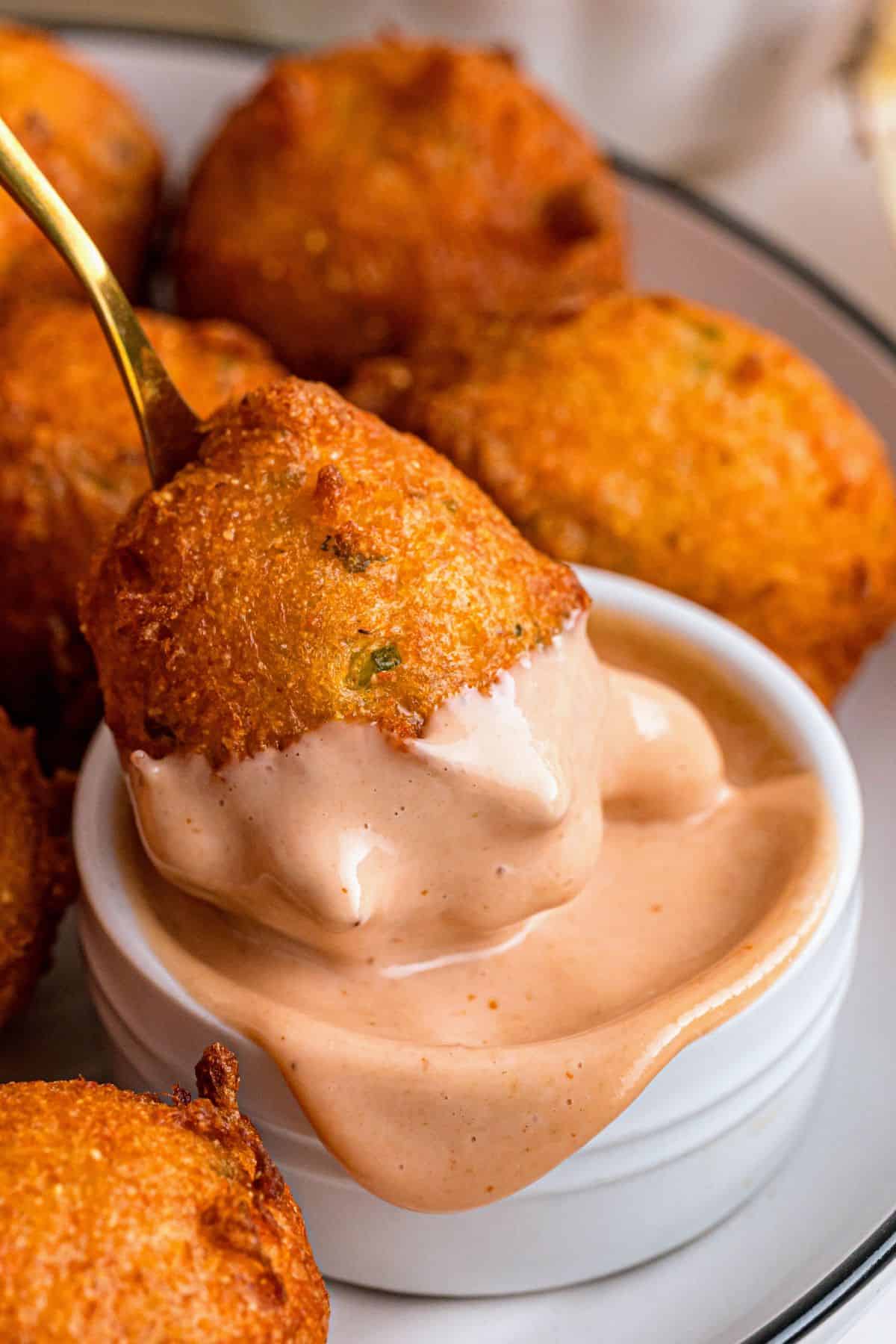 Easy hush puppies recipe served hot with a crispy exterior and a creamy sauce for dipping