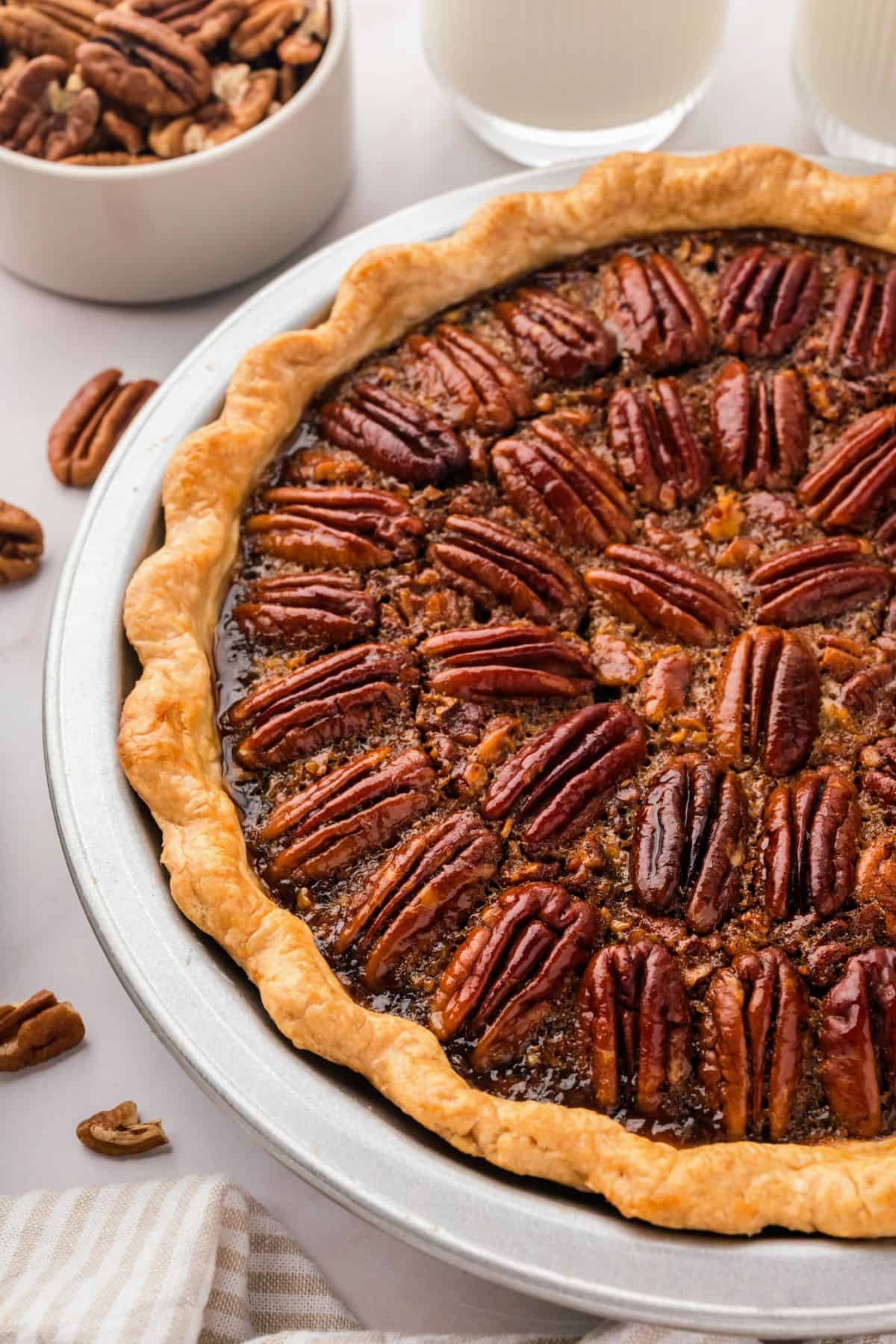 Homemade pecan pie with a glossy filling and crunchy pecans baked until golden brown