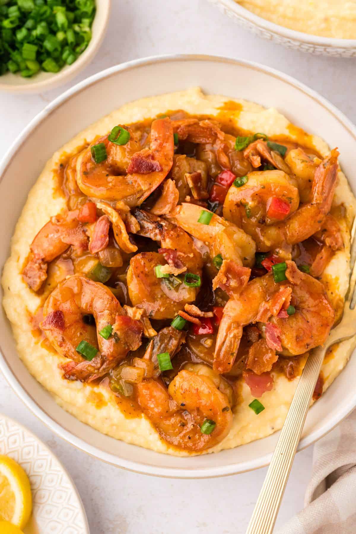 Easy shrimp and grits recipe with tender Cajun shrimp served over thick, creamy cheddar grits