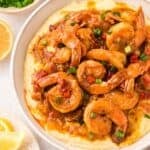 Creamy shrimp and grits topped with Cajun shrimp, crispy bacon pieces, and a rich buttery sauce