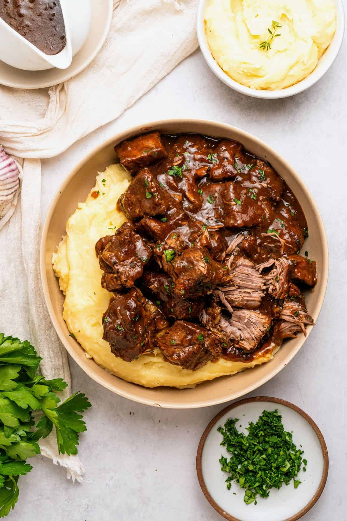 tender beef tips covered in homemade gravy over mashed potatoes for a hearty slow cooker dinner