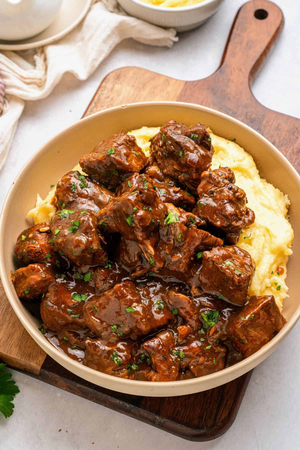 tender beef tips covered in homemade gravy over mashed potatoes for a hearty slow cooker dinner