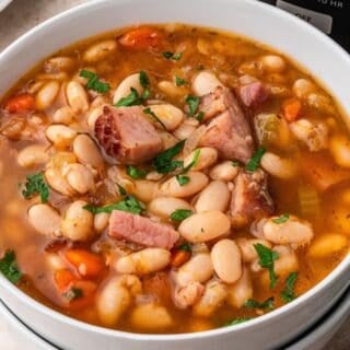 slow cooker ham and bean soup in a bowl topped with chunks of ham