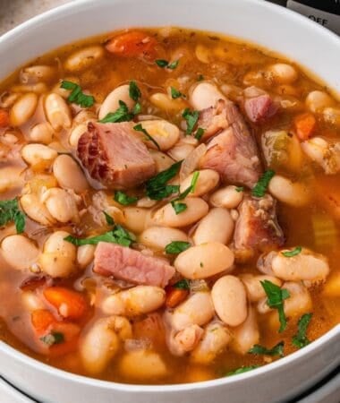 slow cooker ham and bean soup in a bowl topped with chunks of ham