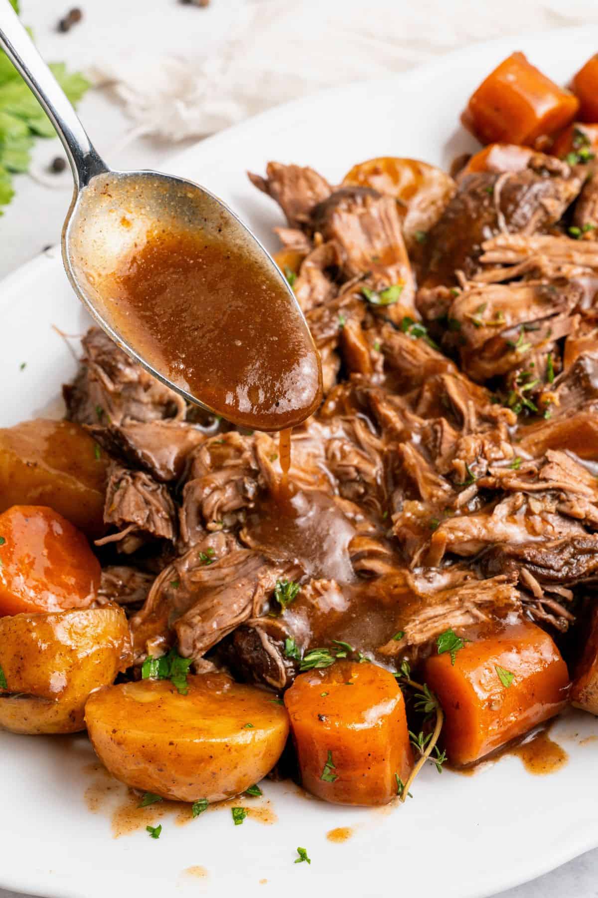 Easy pot roast in a slow cooker with fork-tender beef and vegetables cooked in flavorful broth until soft